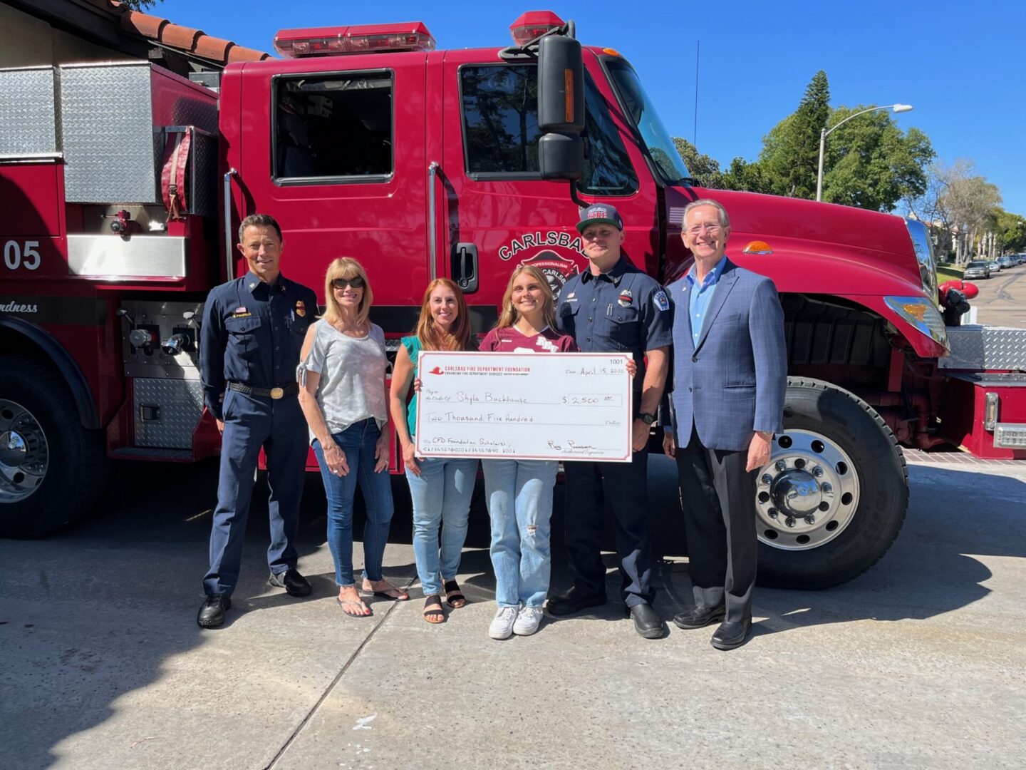 ShlyaBuckhouse_2 Group with large check in front of firetruck.